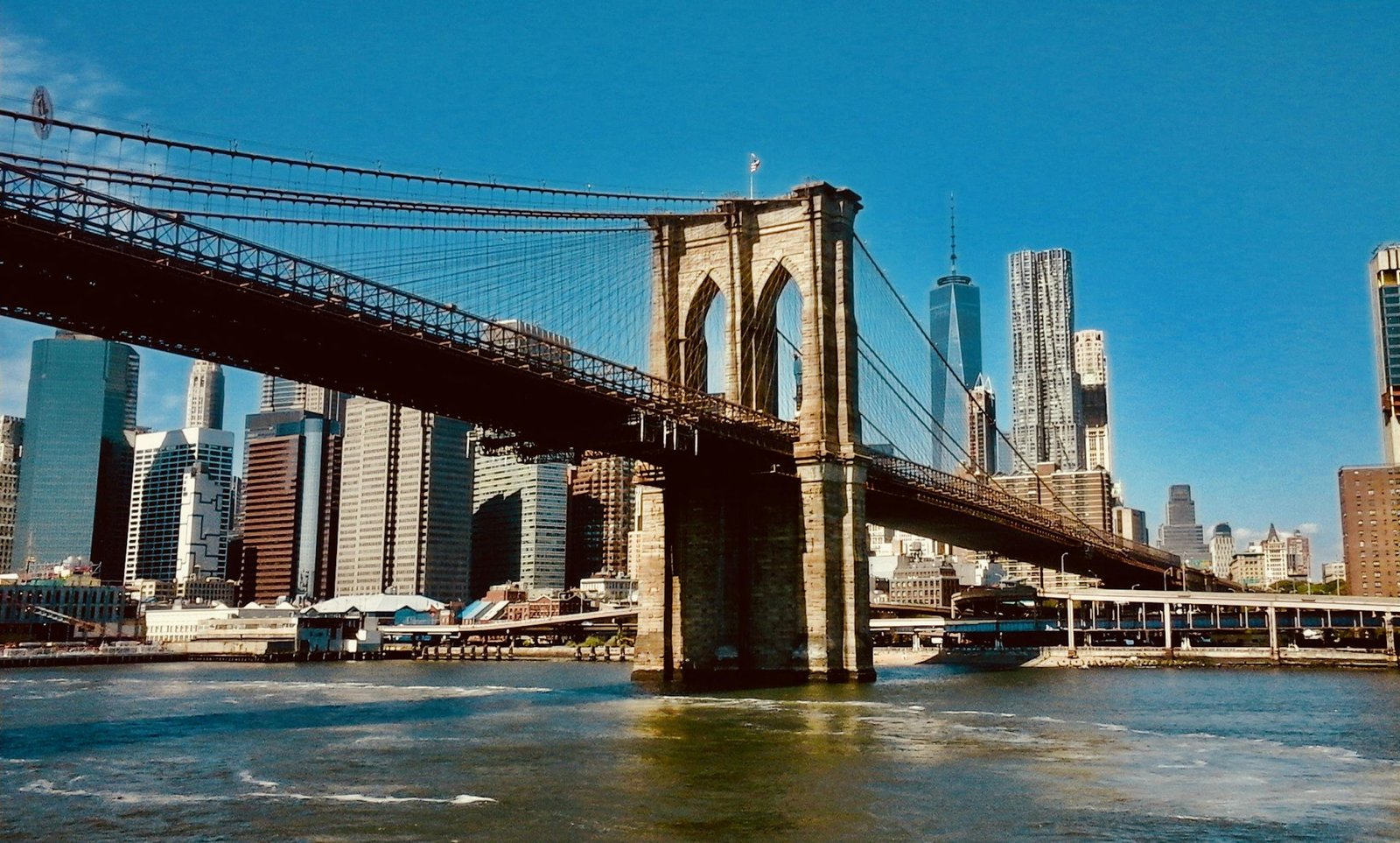 Stunning view of the Brooklyn Bridge and New York City skyline under clear blue skies.