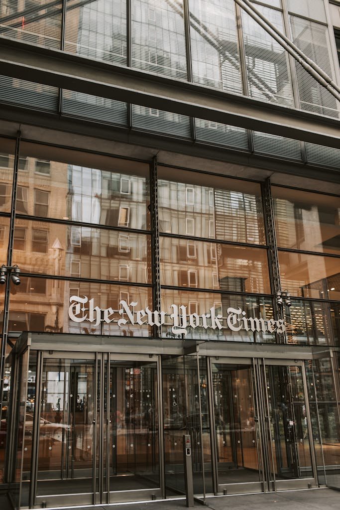 Front entrance of The New York Times building with glass facade in New York City.