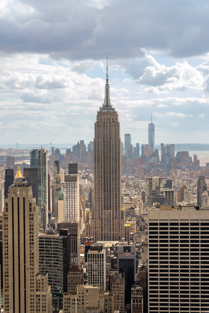 Stunning view of the Empire State Building amidst New York City's skyline under a clouded sky.